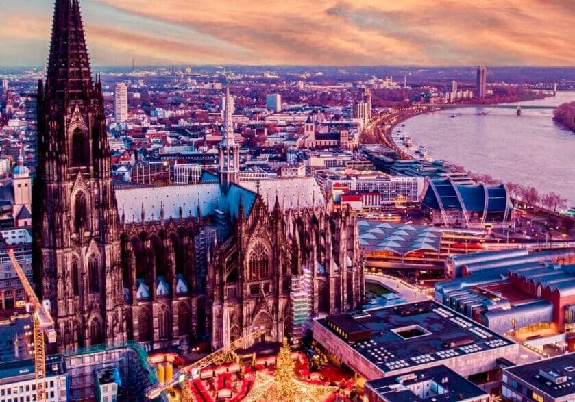 Cologne Cathedral above the Rhine at dusk.